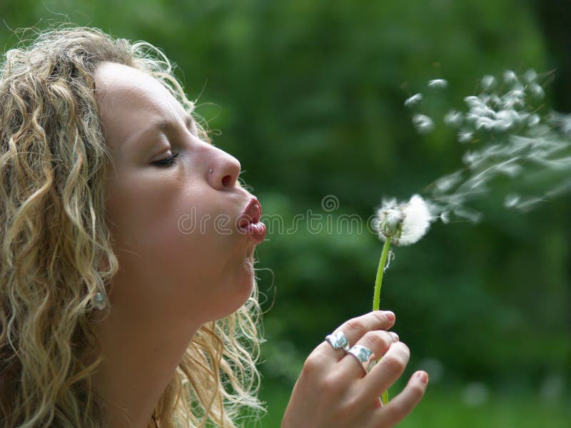 Curly girl blow dandelion