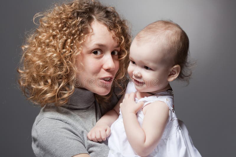 curly mother talking to cute smiling baby