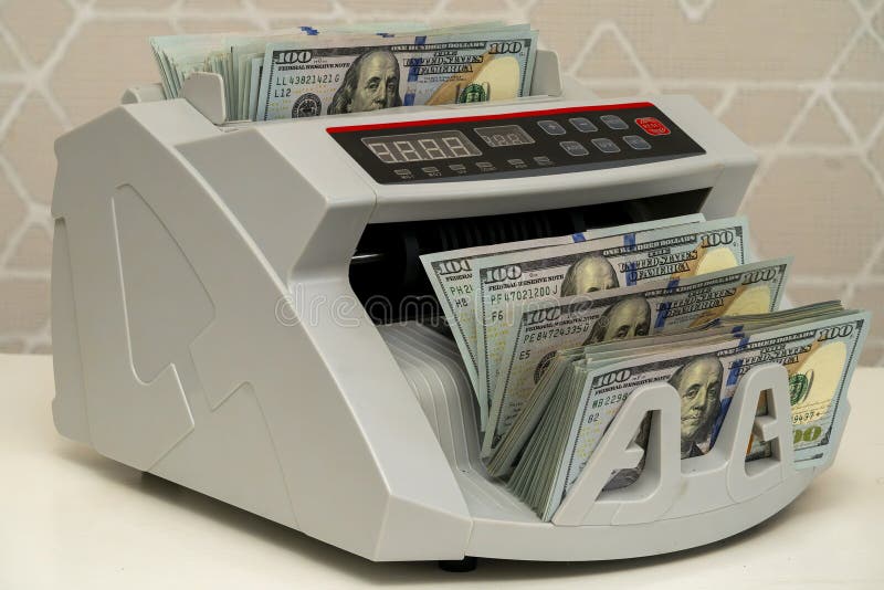 Currency counting machine processing banknotes in a bright setting stock images
