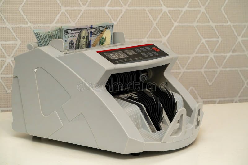 Currency counting machine processing bills in a financial environment royalty free stock image