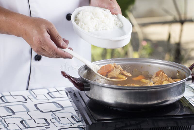 Chef shovel Japanese pork curry with steam rice / cooking Japanese pork curry paste concept. Chef shovel Japanese pork curry with steam rice / cooking Japanese pork curry paste concept