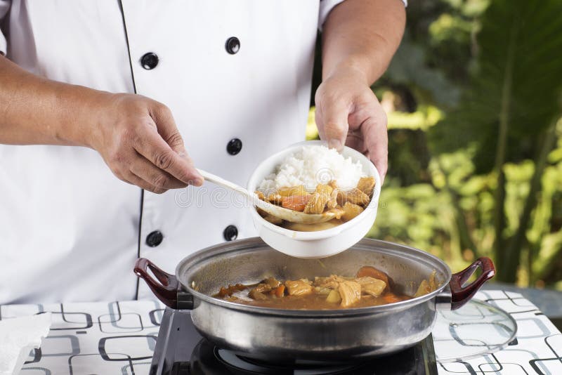 Chef shovel Japanese pork curry with steam rice / cooking Japanese pork curry paste concept. Chef shovel Japanese pork curry with steam rice / cooking Japanese pork curry paste concept