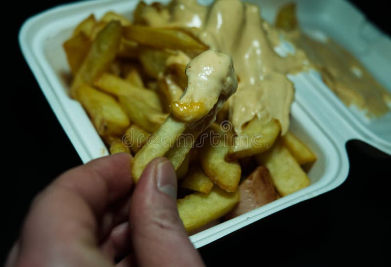 Currywurst med frites i en kopp på svart bakgrund. Traditionell groddjursmat att gå med dip vid korona och vara negativ royaltyfria bilder