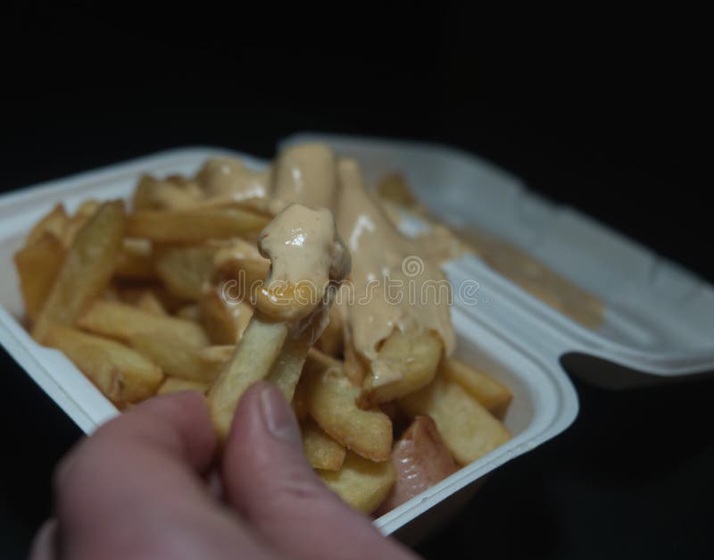 Currywurst med frites i en kopp på svart bakgrund. Traditionell groddjursmat att gå med dip vid korona och vara negativ arkivfoton