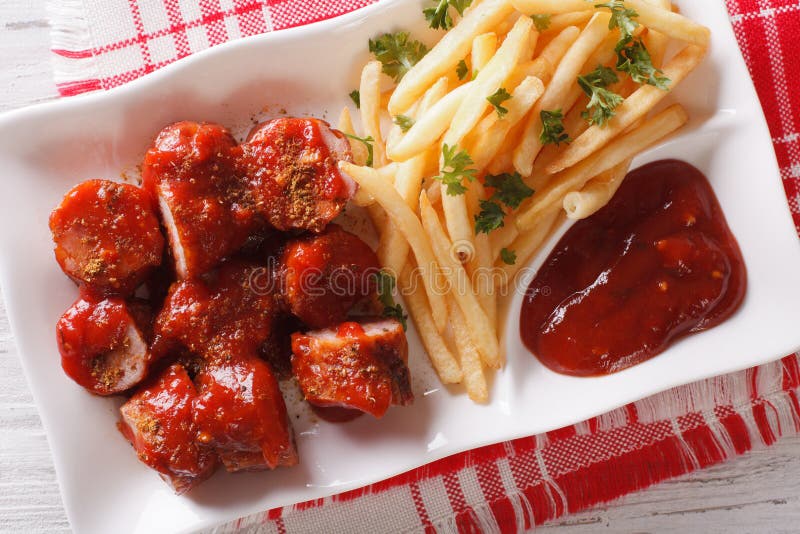 Currywurst och småfisknärbild på en platta horisontalbästa sikt royaltyfria foton