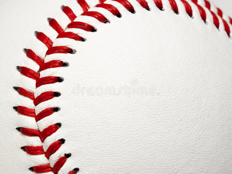 The curved red stitches of a baseball framing area for copy on white leather baseball surface. The curved red stitches of a baseball framing area for copy on white leather baseball surface