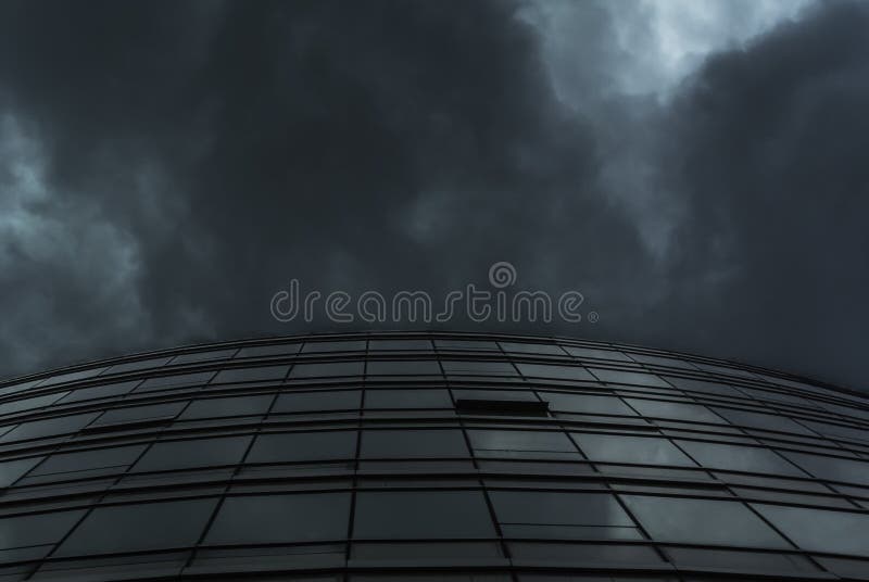 Curve glass building facade under rain cloud