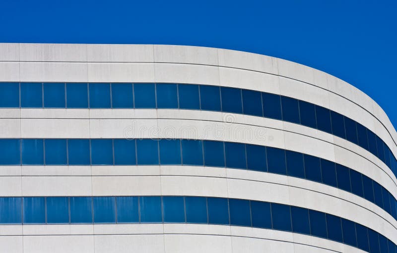 A curved concrete and blue glass office building