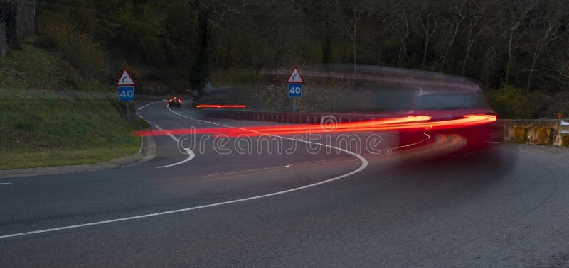Curvy road and car lights stock image. Image of fast 236520503