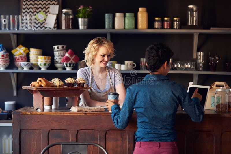 Customer In Coffee Shop Ordering Using Digital Tablet stock photos Customer In Coffee Shop Ordering Using Digital Tablet stock photos