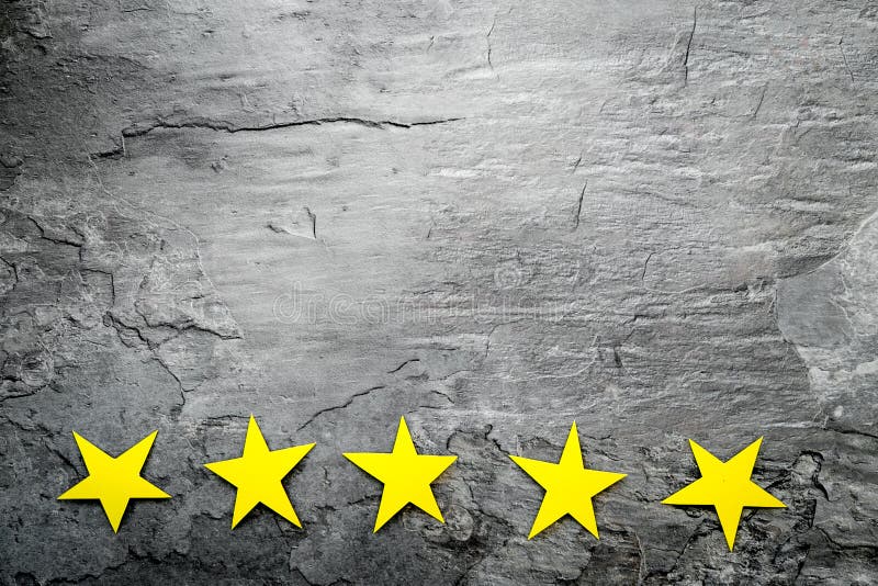 Customer experience concept. Estimate service quality. Five stars on grey background top-down copy space royalty free stock image Customer experience concept. Estimate service quality. Five stars on grey background top-down copy space royalty free stock image