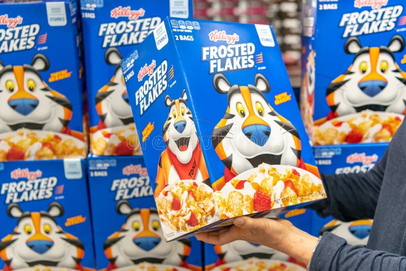 Customer hand holding a box of Kelloggâ€™s brand Frosted Flakes Cereal