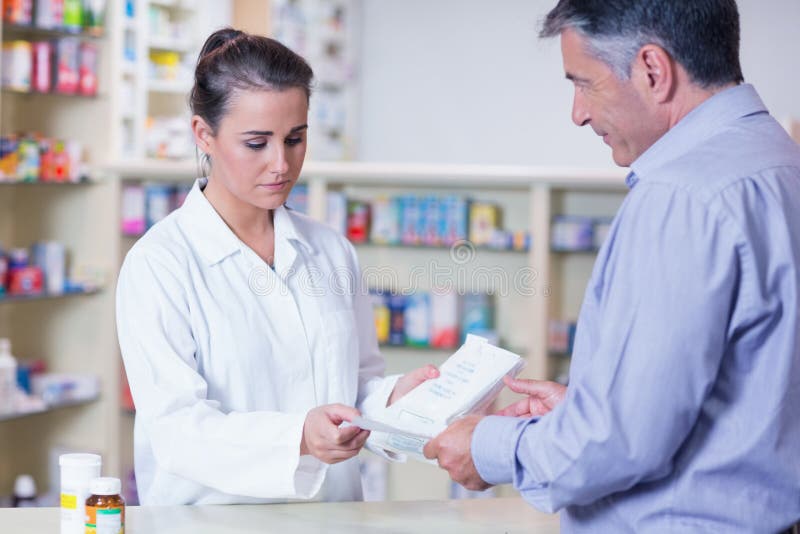 Customer Handing a Prescription To a Trainee Stock Photo Image of