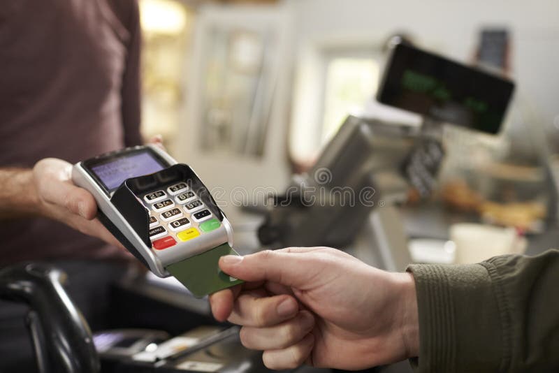 Customer makes credit card payment over counter at a cafe