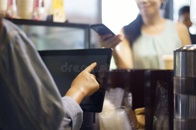 Customer order food and drink, using her smartphone and nfs high technology to pay a barista for her purchase with phone, mobile royalty free stock photography Customer order food and drink, using her smartphone and nfs high technology to pay a barista for her purchase with phone, mobile royalty free stock photography