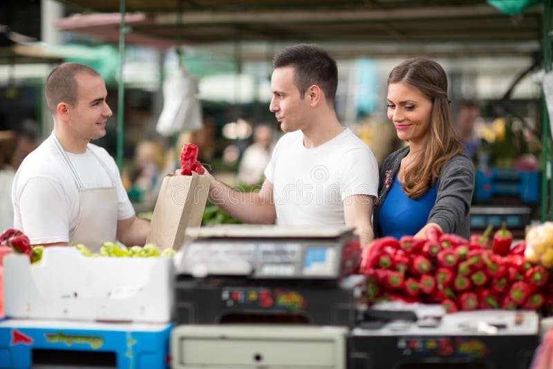 Customer picking pepper from salesman at street market royalty free stock photography Customer picking pepper from salesman at street market royalty free stock photography