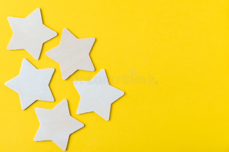 Customer reviews or CX, Custome Experience concept, 5 wooden stars on solid yellow background with copy space, the satisfaction rating or feedback on quality of products and services from real user.
