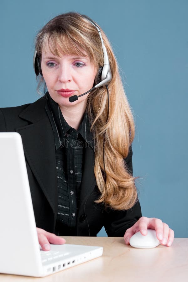 A customer service agent answering the telephone and checking information in the computer. A customer service agent answering the telephone and checking information in the computer