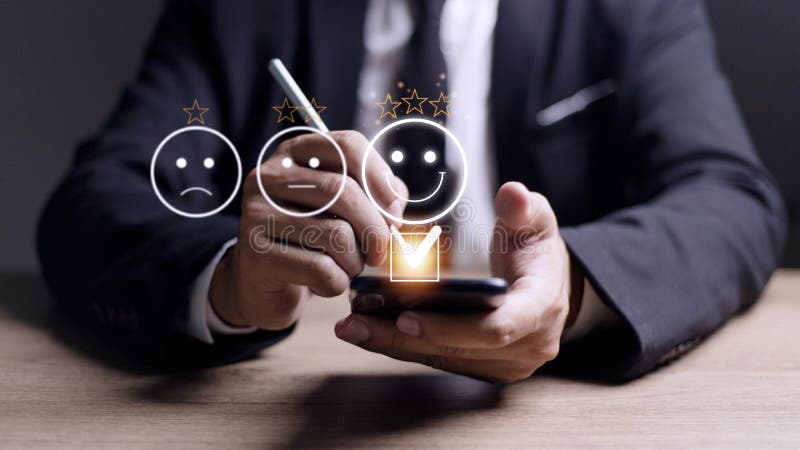 Customer service evaluation concept. using a smartphone is pressing face emoticon smiling in satisfaction on virtual touch screen royalty free stock photo