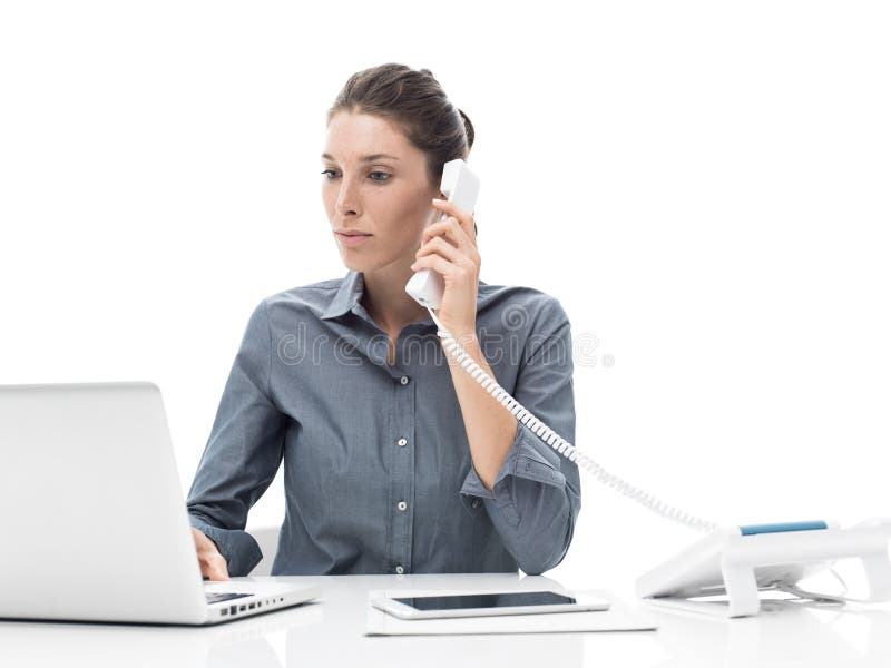 Customer service operator on the phone, she is helping a customer and using a laptop