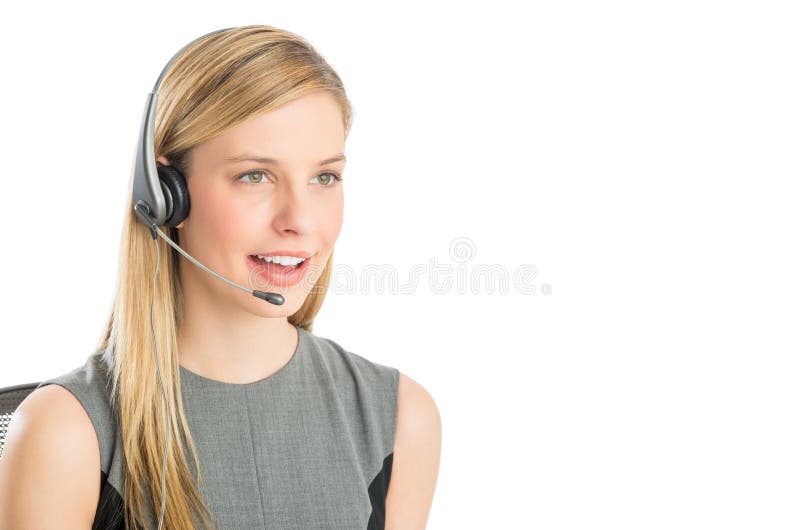 Close-up of beautiful customer service representative wearing headset looking away against white background