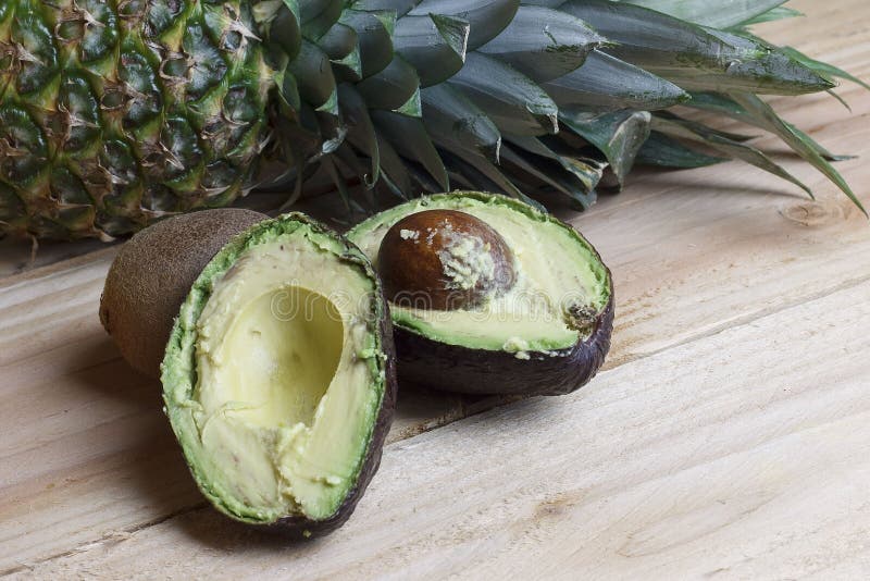 Cut in half avocado and pineapple royalty free stock image