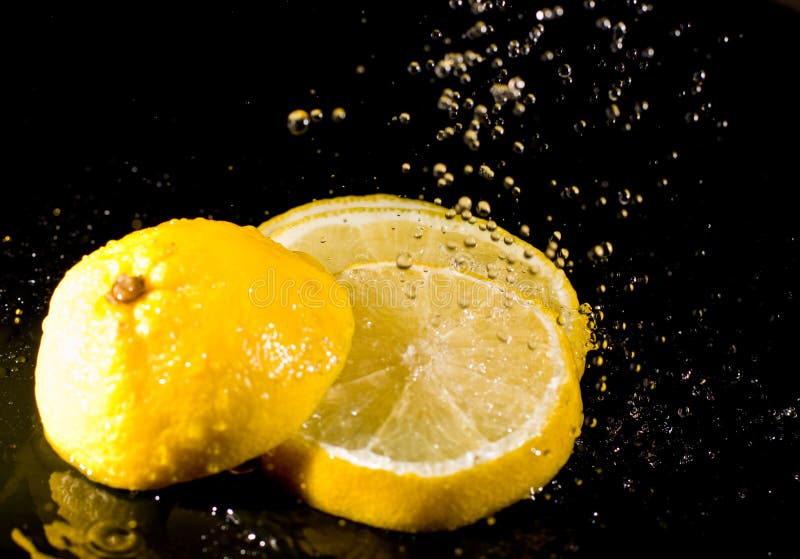 Cut lemon under water splashes stock images Cut lemon under water splashes stock images