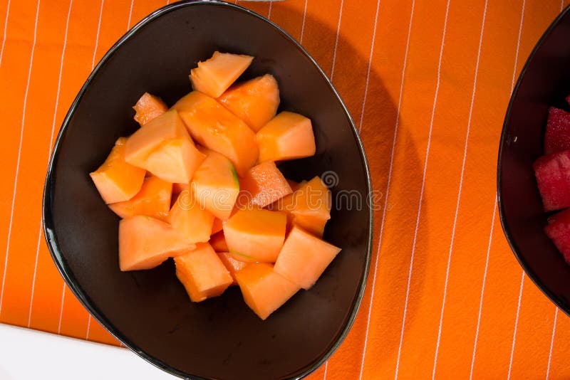 Cut Melon Black Plate Under Orange Napkin Stock Photos Free & Royalty