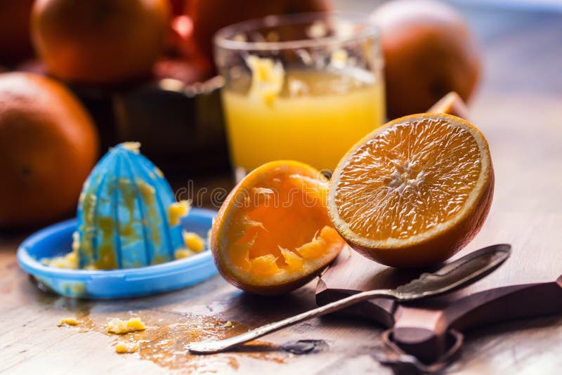 Cut oranges. Pressed orange manual method. Oranges and sliced oranges with juice and squeezer. royalty free stock image