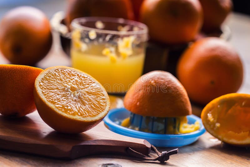 Cut oranges. Pressed orange manual method. Oranges and sliced oranges with juice and squeezer. royalty free stock image