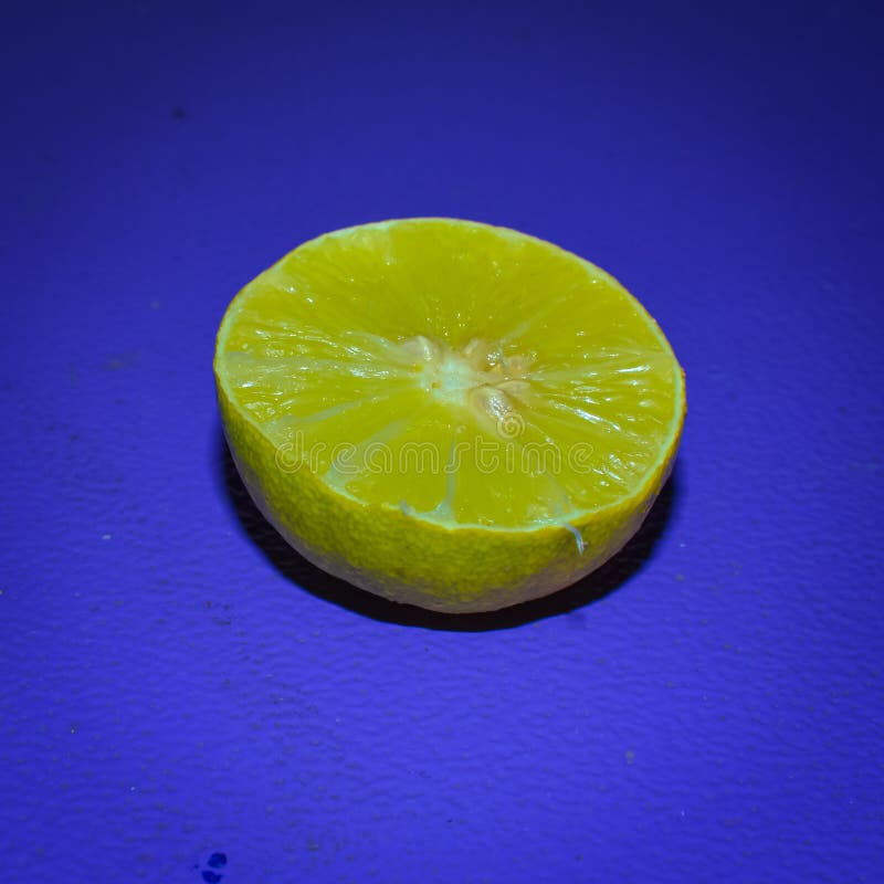 Cut Piece Ripe Yellow Lemon On Blue Background. royalty free stock photography