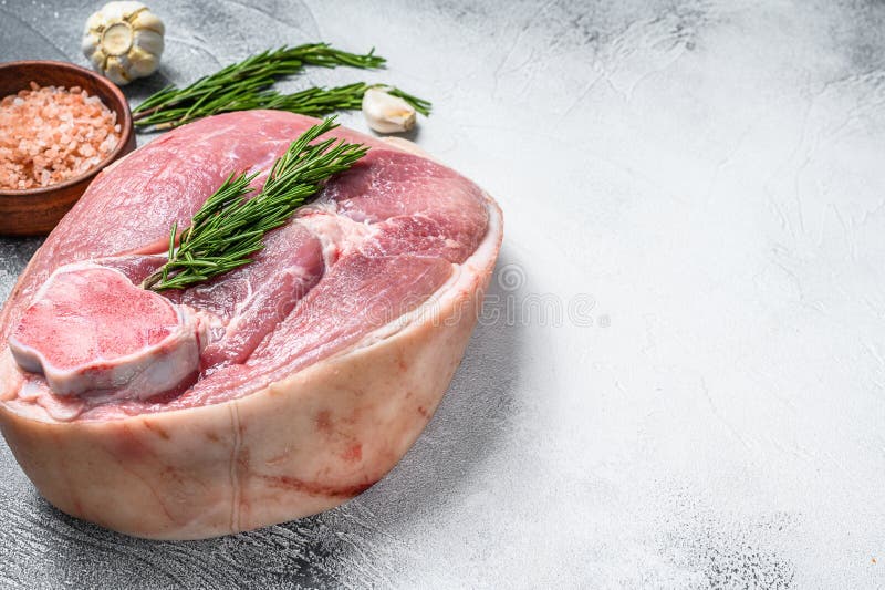 Cut of raw pork knuckle, leg on a table. Farm fresh meat. Gray background. Top view. Copy space