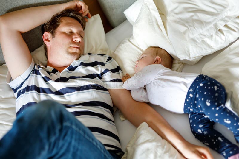 Cute adorable baby girl of 6 months and her father sleeping peaceful in bed at home royalty free stock image Cute adorable baby girl of 6 months and her father sleeping peaceful in bed at home royalty free stock image