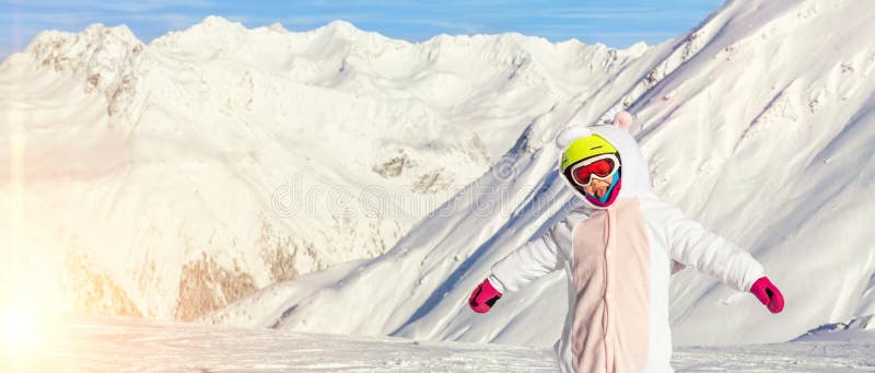 Cute adorable preschooler caucasian kid girl portrait with ski in helmet, goggles and unicorn fun costume enjoy winter sport