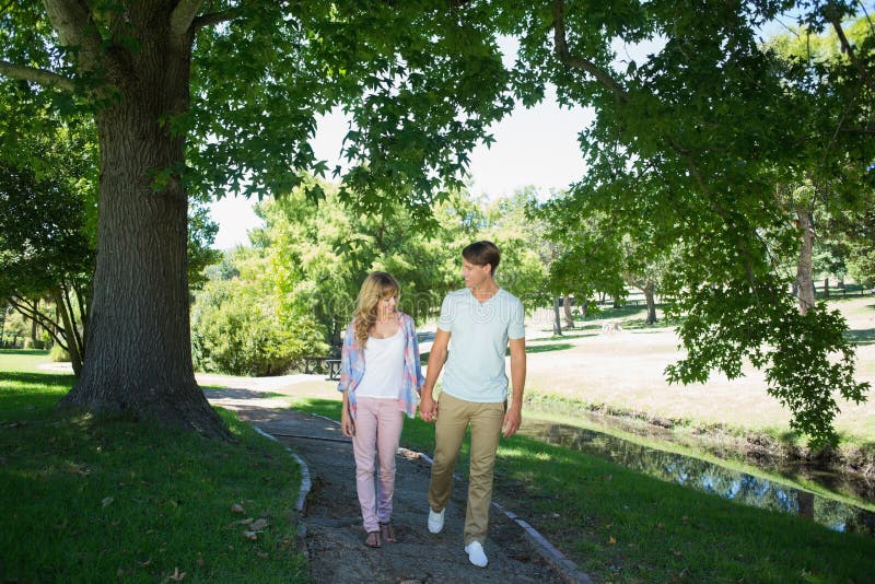 Cute Affectionate Couple Walking Hand in Hand in the Park Stock Photo