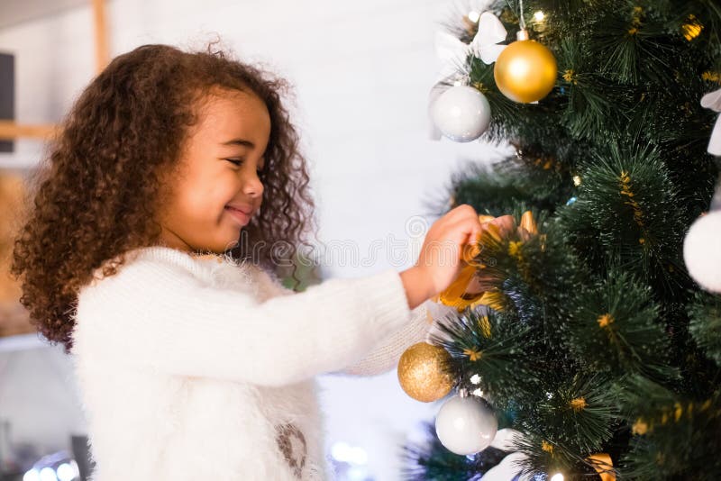 Cute african american girl decorating Christmas tree stock photography Cute african american girl decorating Christmas tree stock photography