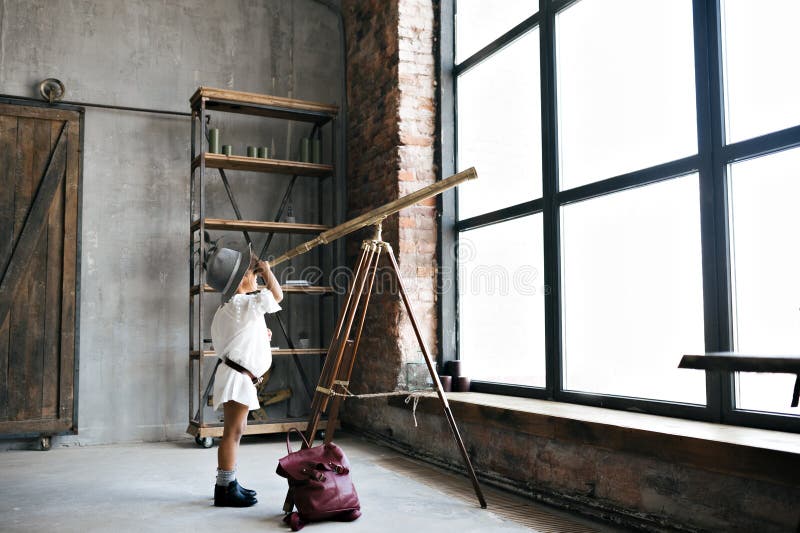Cute african american kid girl looks through the telescope royalty free stock photos