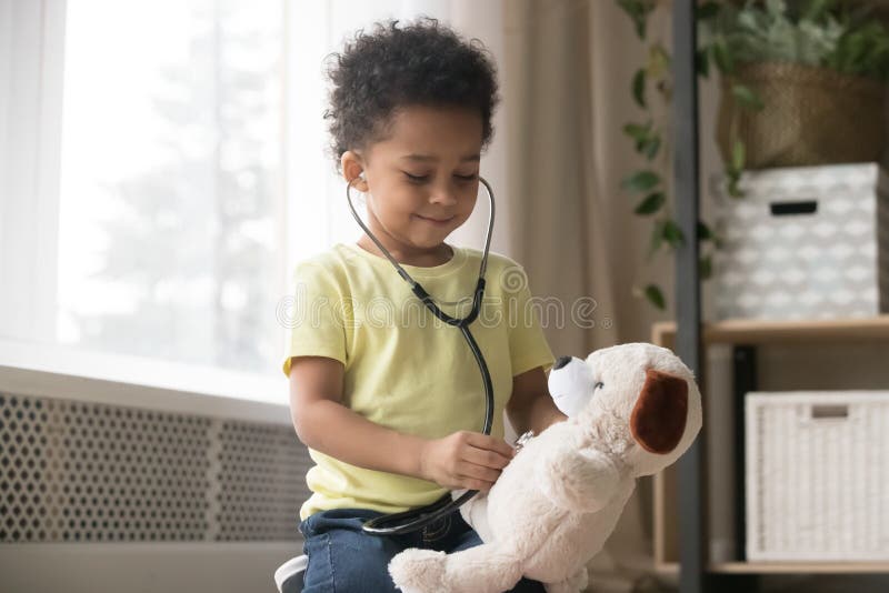 Cute african boy playing with toy as doctor holding stethoscope