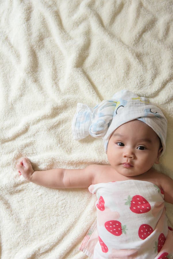 Cute Asian Baby Girl with a Towel on Her Head Lying on the Bed after ...