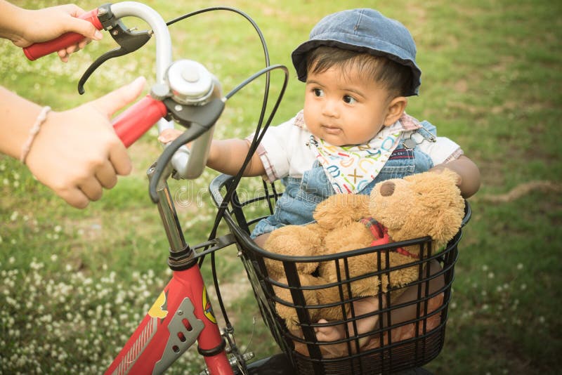 Cute asian baby sitting in bicycle basket,vintage tone