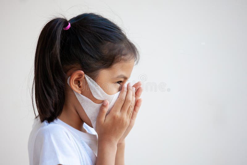 Cute asian child girl wearing protection mask to against air smog pollution with PM 2.5, anti smog and viruses.