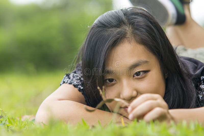 Cute asian girl laying on the grass