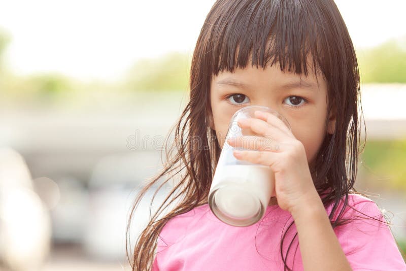 Cute Asian Girl with Long Hair Wearing a Pink Shirt Right Hand Holding a  Glass of Milk Drinking Milk in a Glass Drinking Milk Stock Photo - Image of  fresh, hand: 184829236