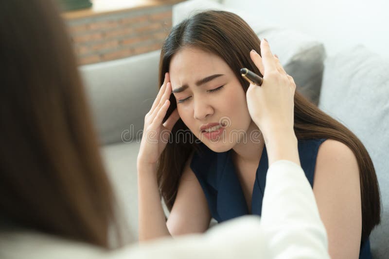 Cute Asian girl met hoofdpijn Dus ging ze naar een dokter om de symptomen te controleren Begrip gezondheid en ziekte royalty-vrije stock foto Cute Asian girl met hoofdpijn Dus ging ze naar een dokter om de symptomen te controleren Begrip gezondheid en ziekte royalty-vrije stock foto
