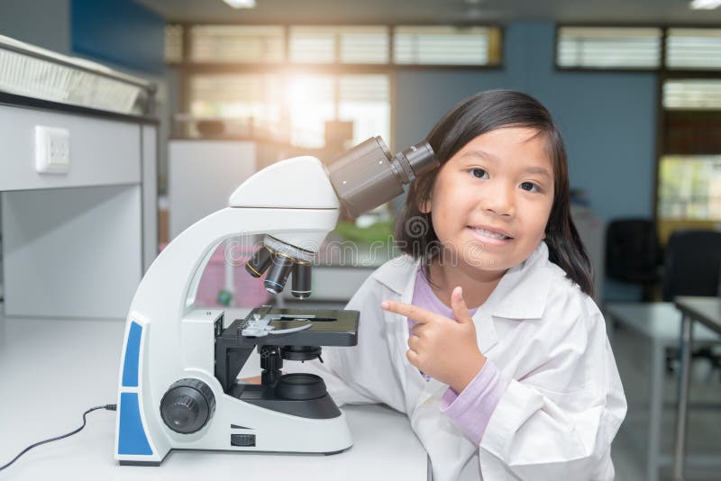 Cute asian scientist girl working with microscope stock image Cute asian scientist girl working with microscope stock image