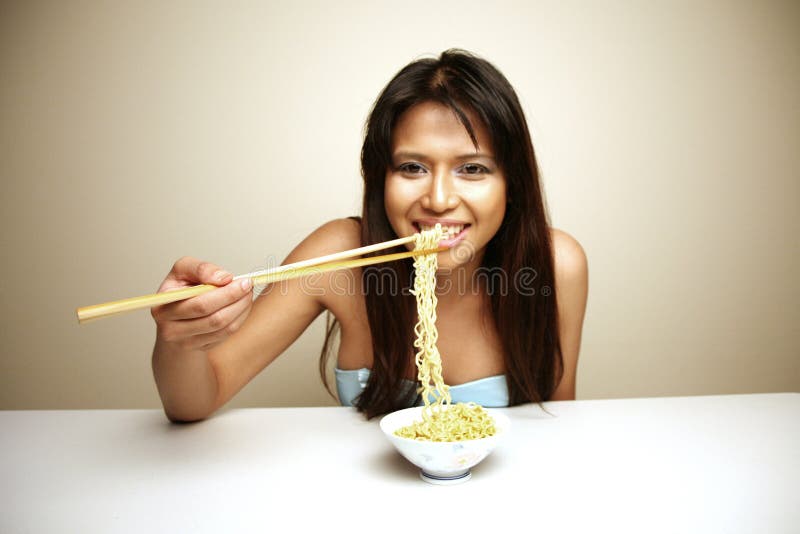 Cute Asian woman eating noodles