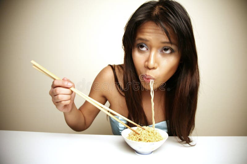 Cute Asian woman eating noodles