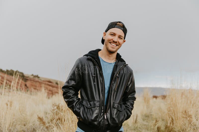 Young Cute Modern Caucasian Woman Smiling in Front of Massive Natural Red Rock Stone Wall Outside in Nature at the State Park