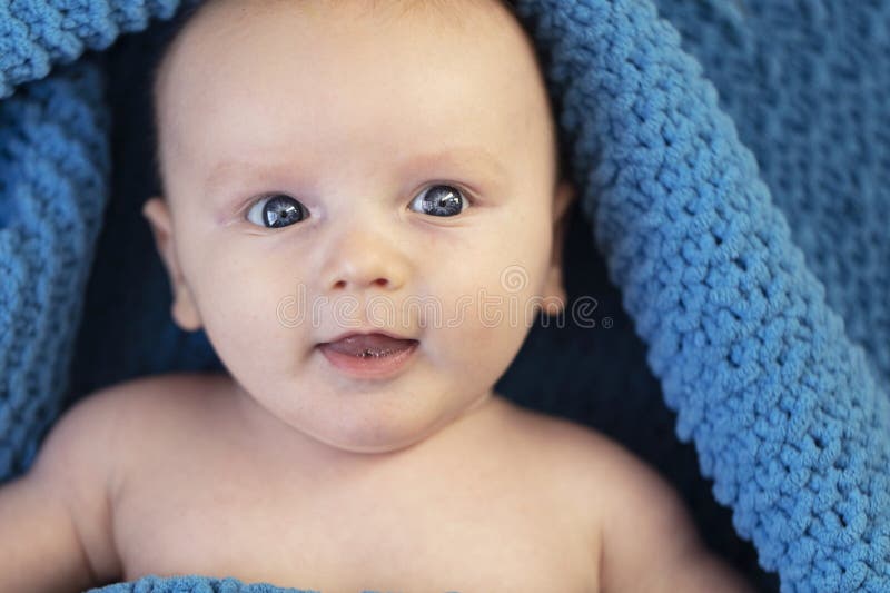 A Cute Baby Boy Wrapped in a Cosy Blue Blanket Looking at the Camera Stock Image Image of