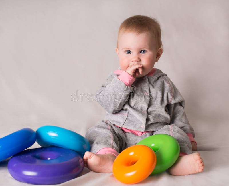 Cute Baby with Colorful Toys on Grey Background. Stock Image - Image of ...